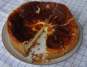 The cheesecake on the plate being cut into pieces for hungry colleagues.