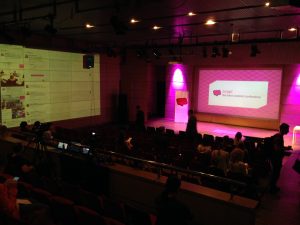 View of the stage for the soap! conference with the logo displayed on large monitor